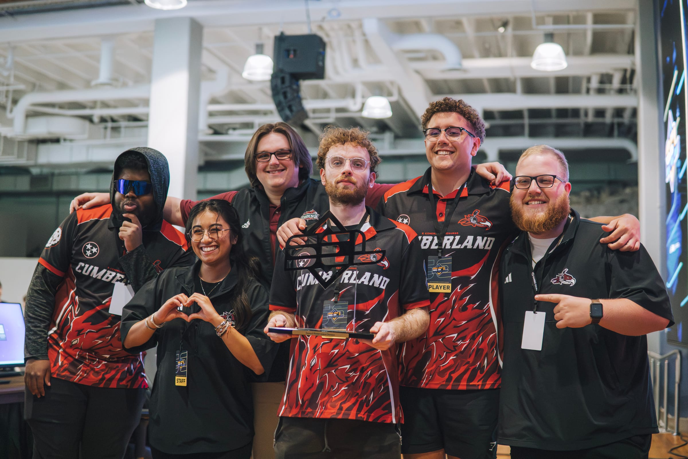 Team and Gaming Oasis staff celebrate a LAN finals win with a trophy